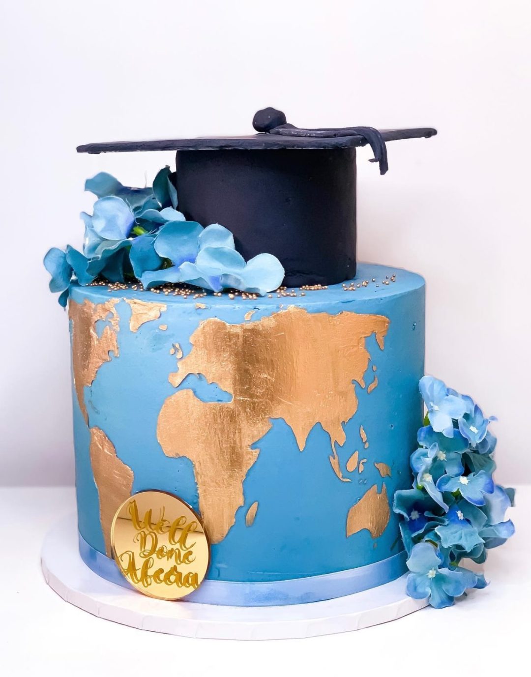 Blue graduation cake with world map for geography grads
