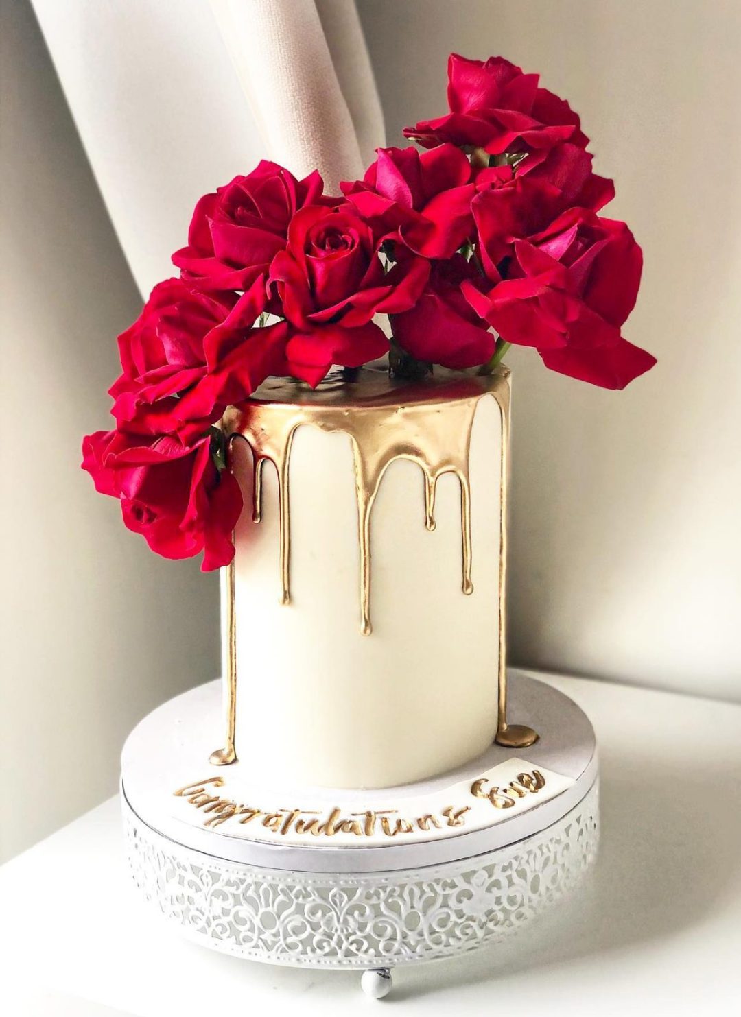 Elegant graduation cake with roses and dripping gold