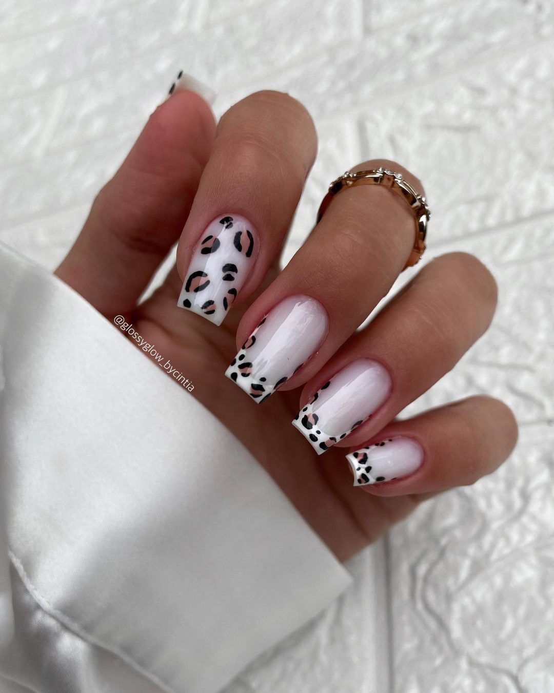 Unhas elegantes com estampa de leopardo branco.