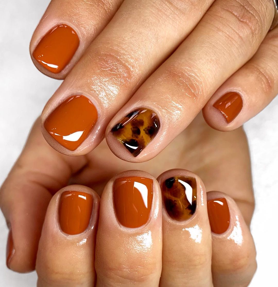 Unhas de gel laranja queimado com estampa animal