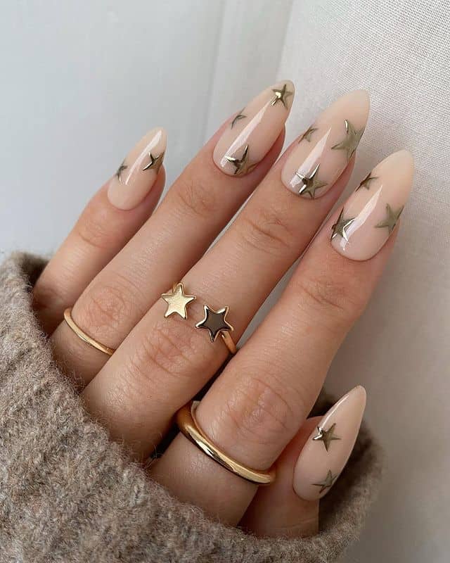 Lindas unhas nude de amêndoa com decalques de estrelas