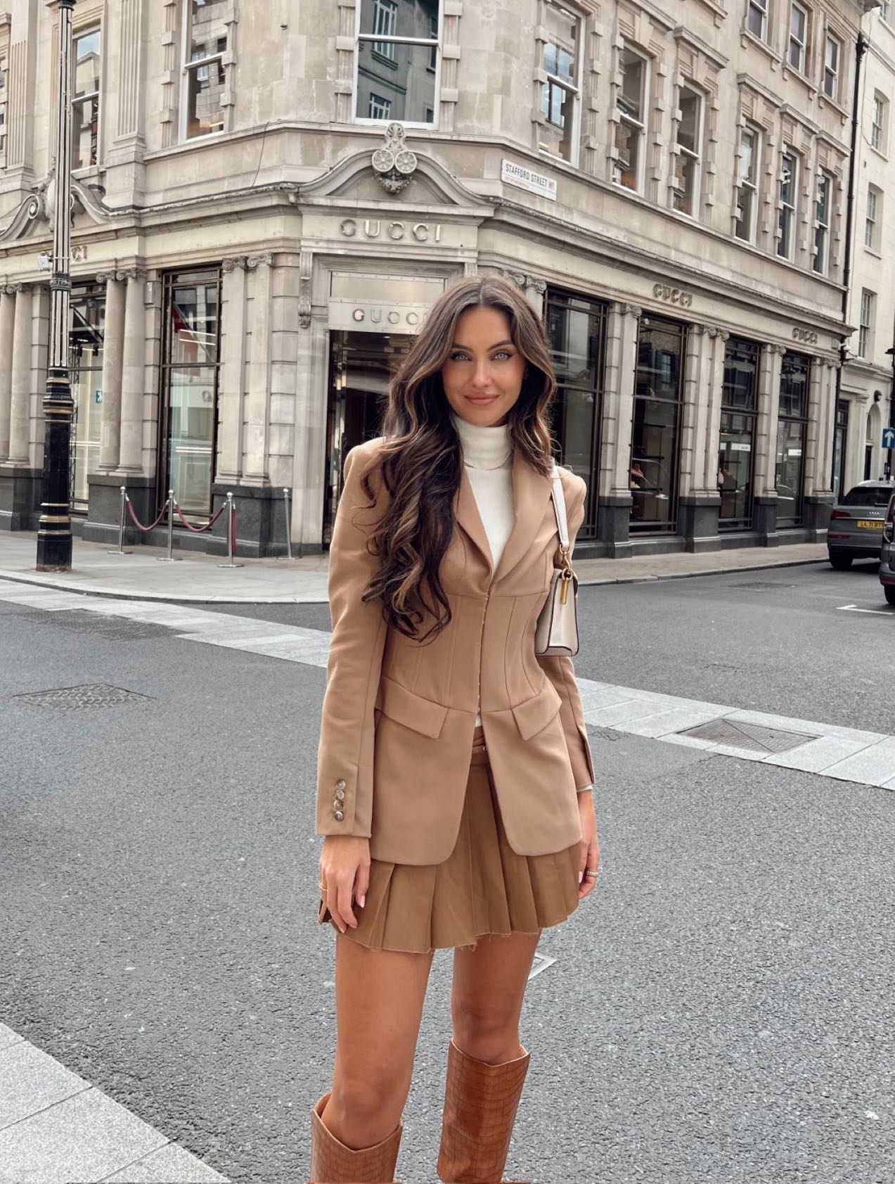 Preppy light academia outfit with beige blazer and knee high boots.