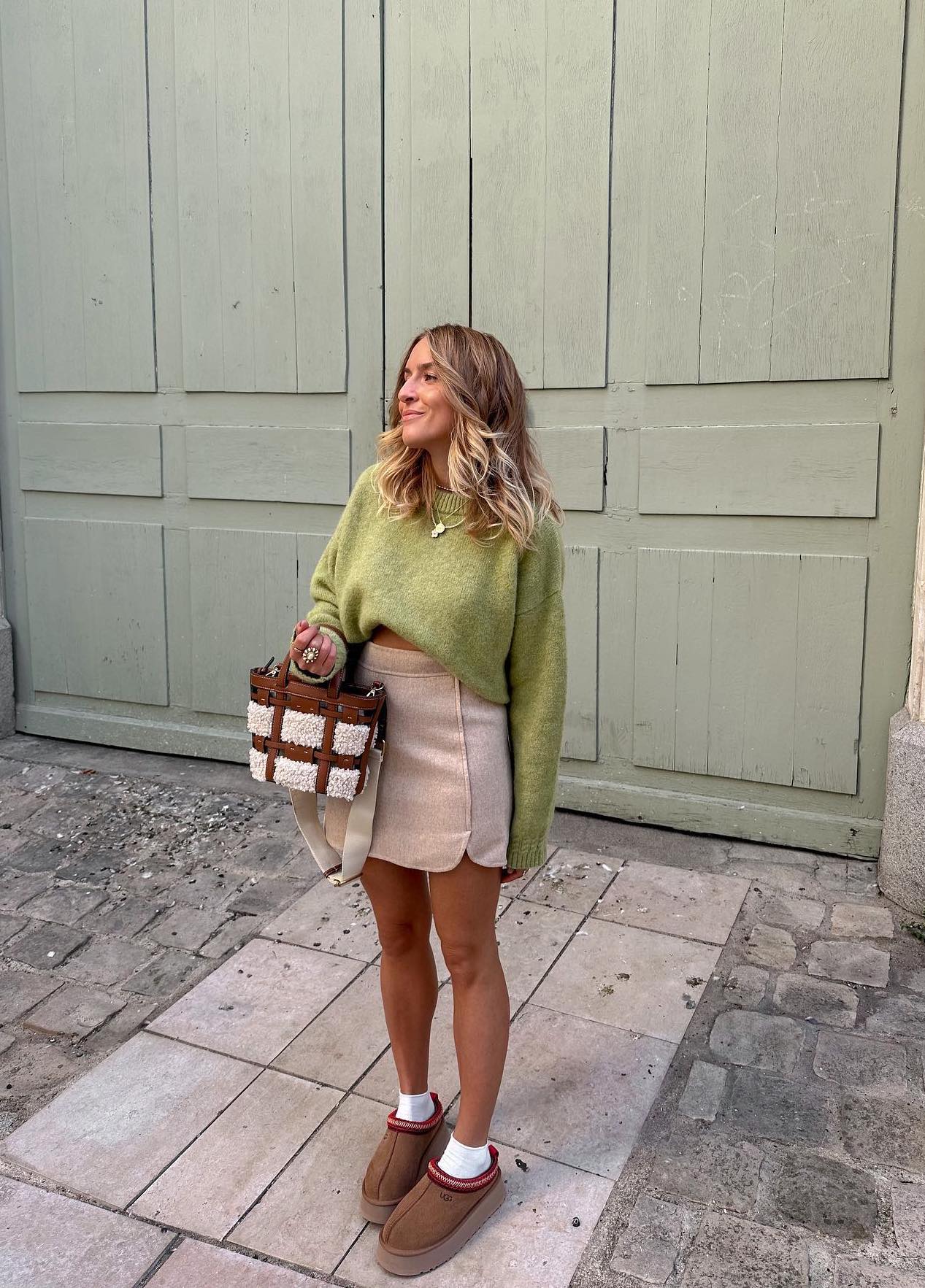 Casual spring outfit with light green sweater and Ugg Tazz slippers.