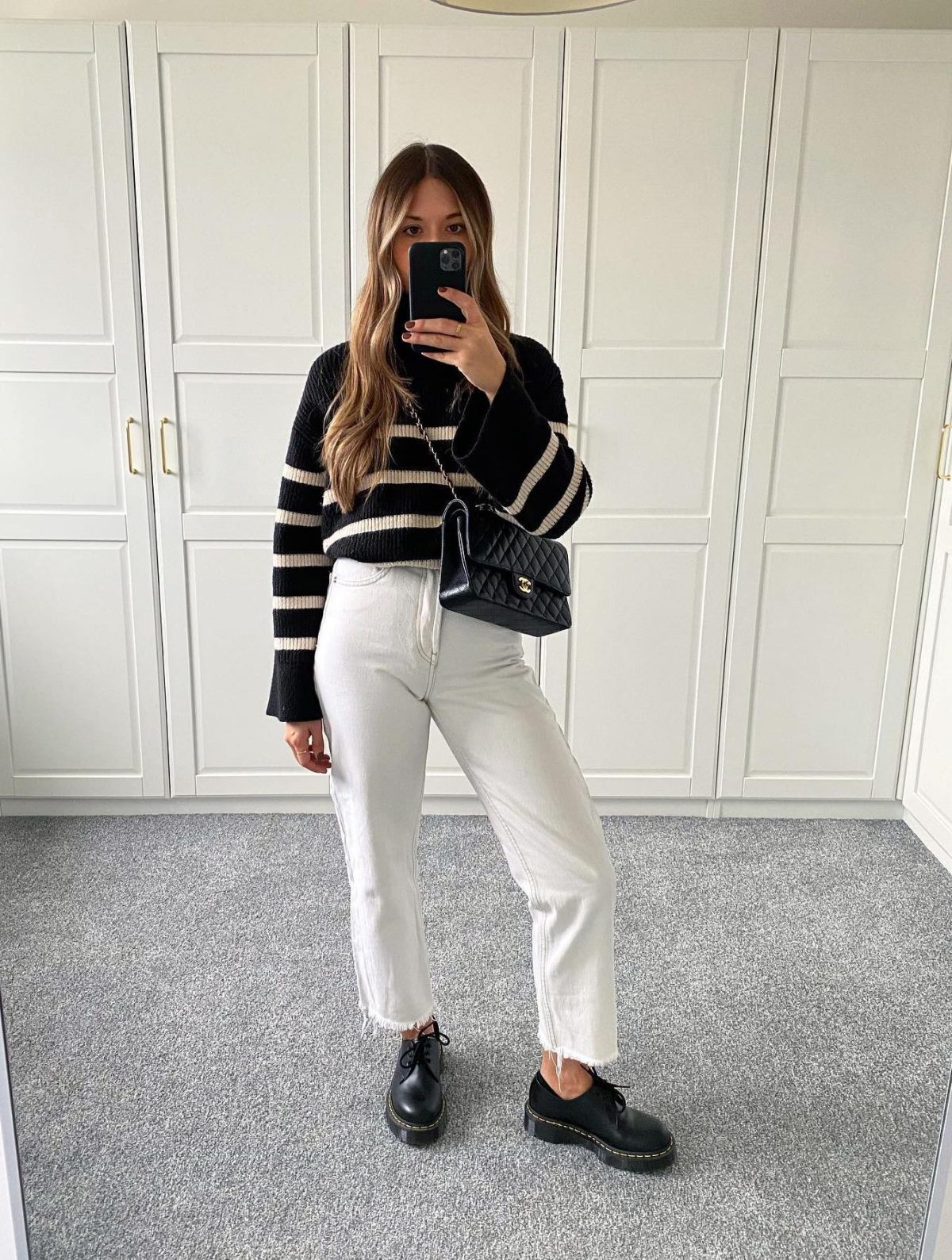 Business casual outfit with white jeans, striped sweater and Doc Martens 1461 Bex shoes.