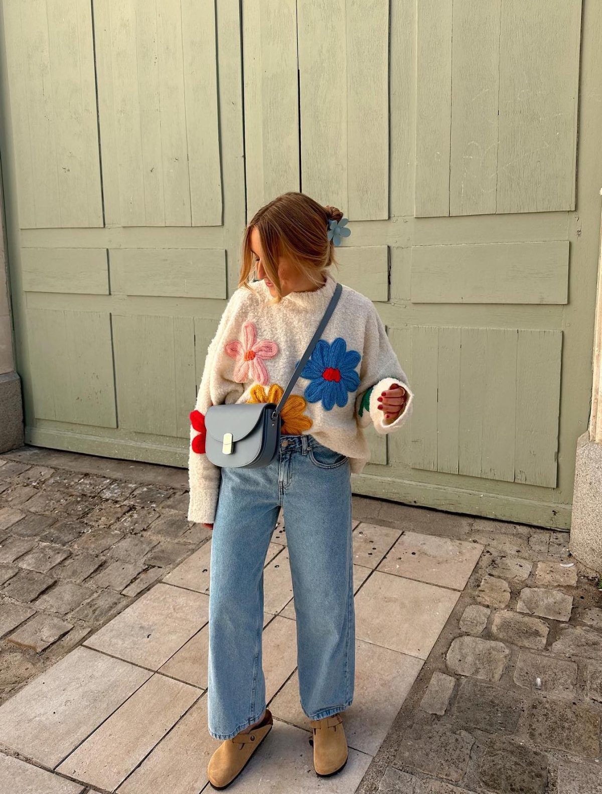 Casual Easter outfit with a flower sweater and jeans.