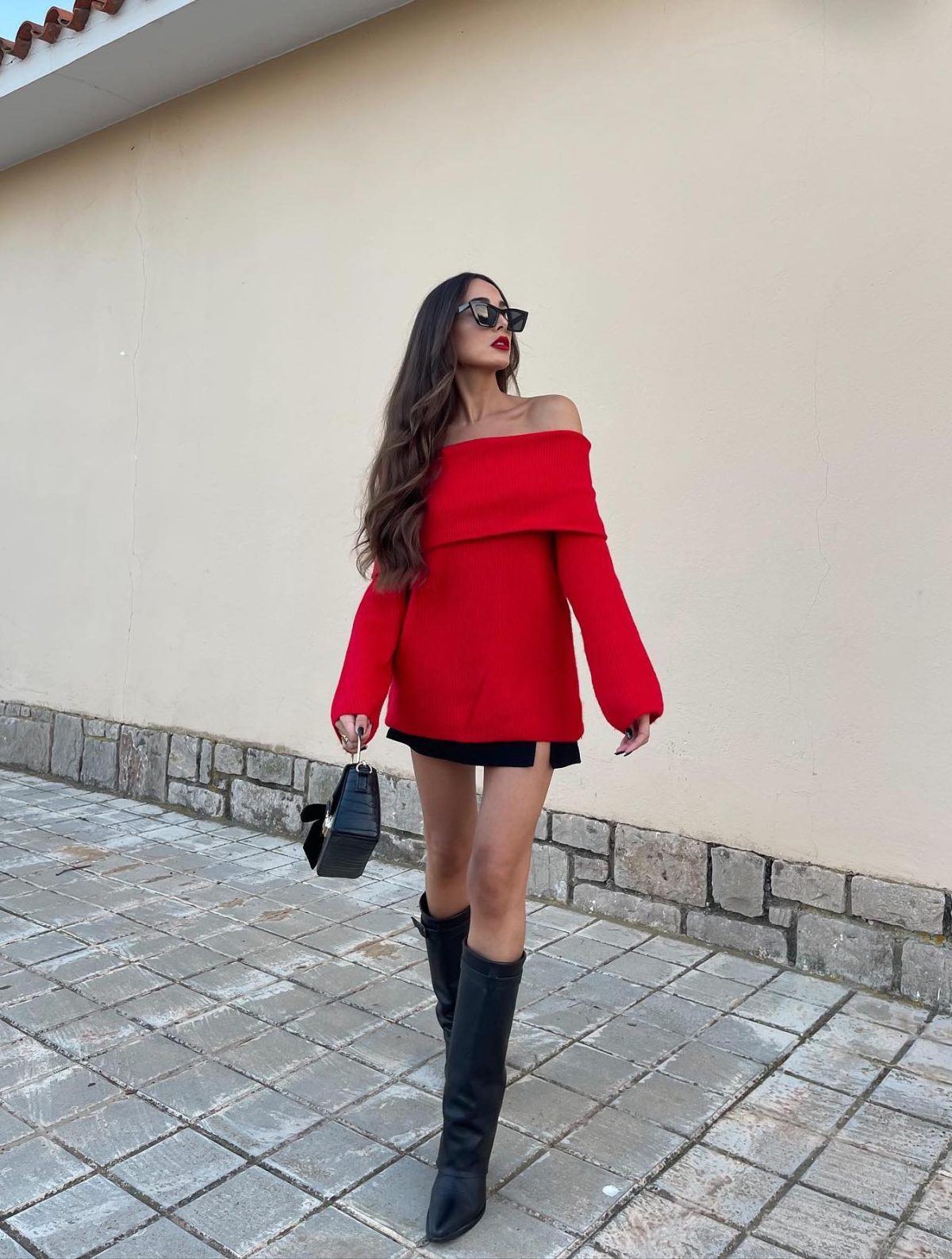 Red sweater with black knee high boots.