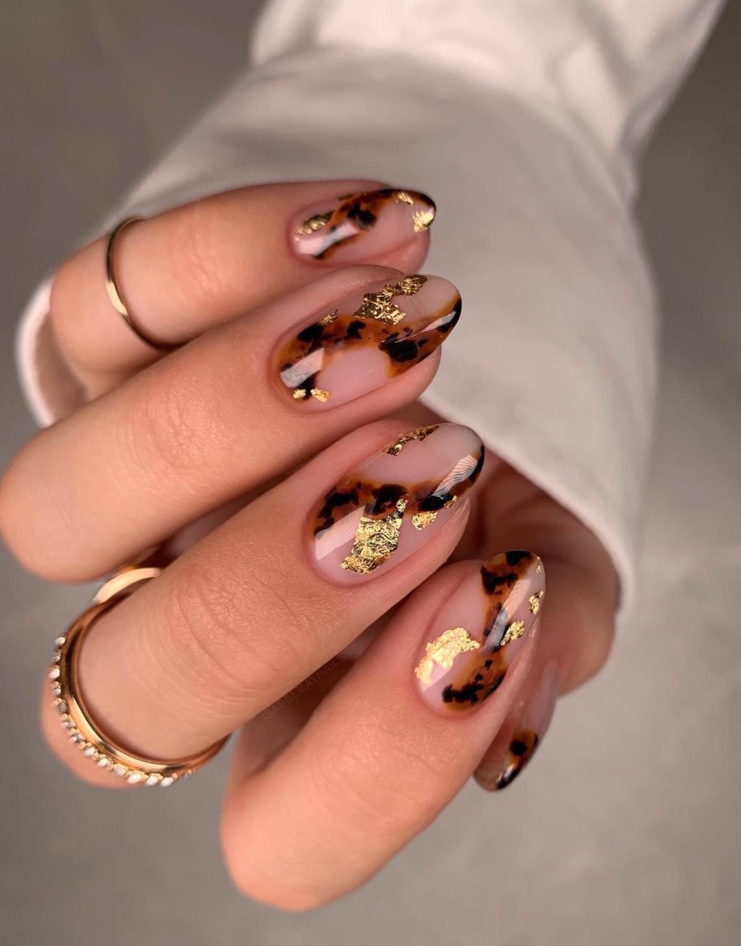 Tortoiseshell swirl nails with gold flakes