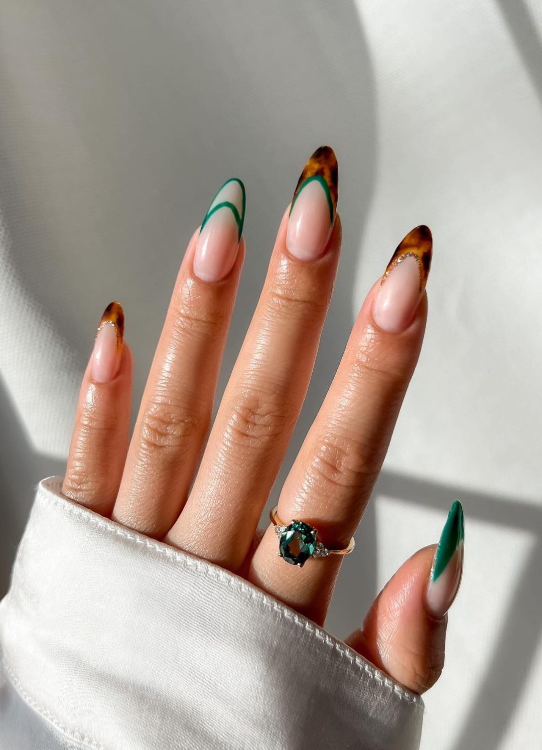 Tortoiseshell French tip nails with emerald green lines