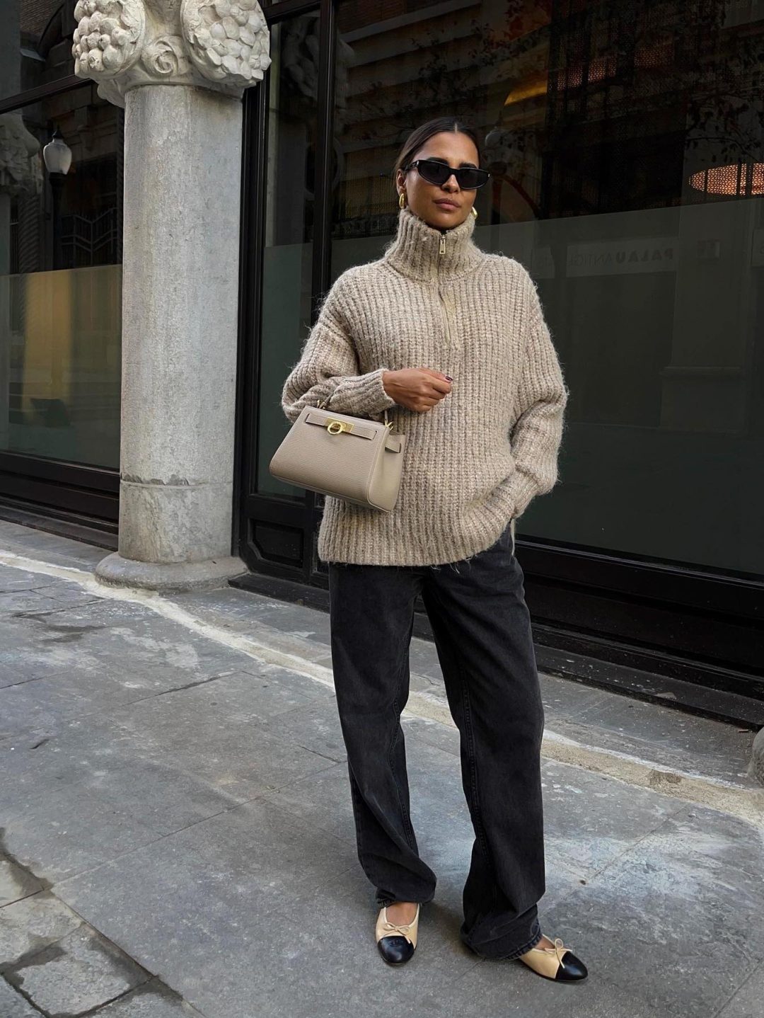 Cozy fall outfit with beige turtleneck sweater and black baggy jeans.