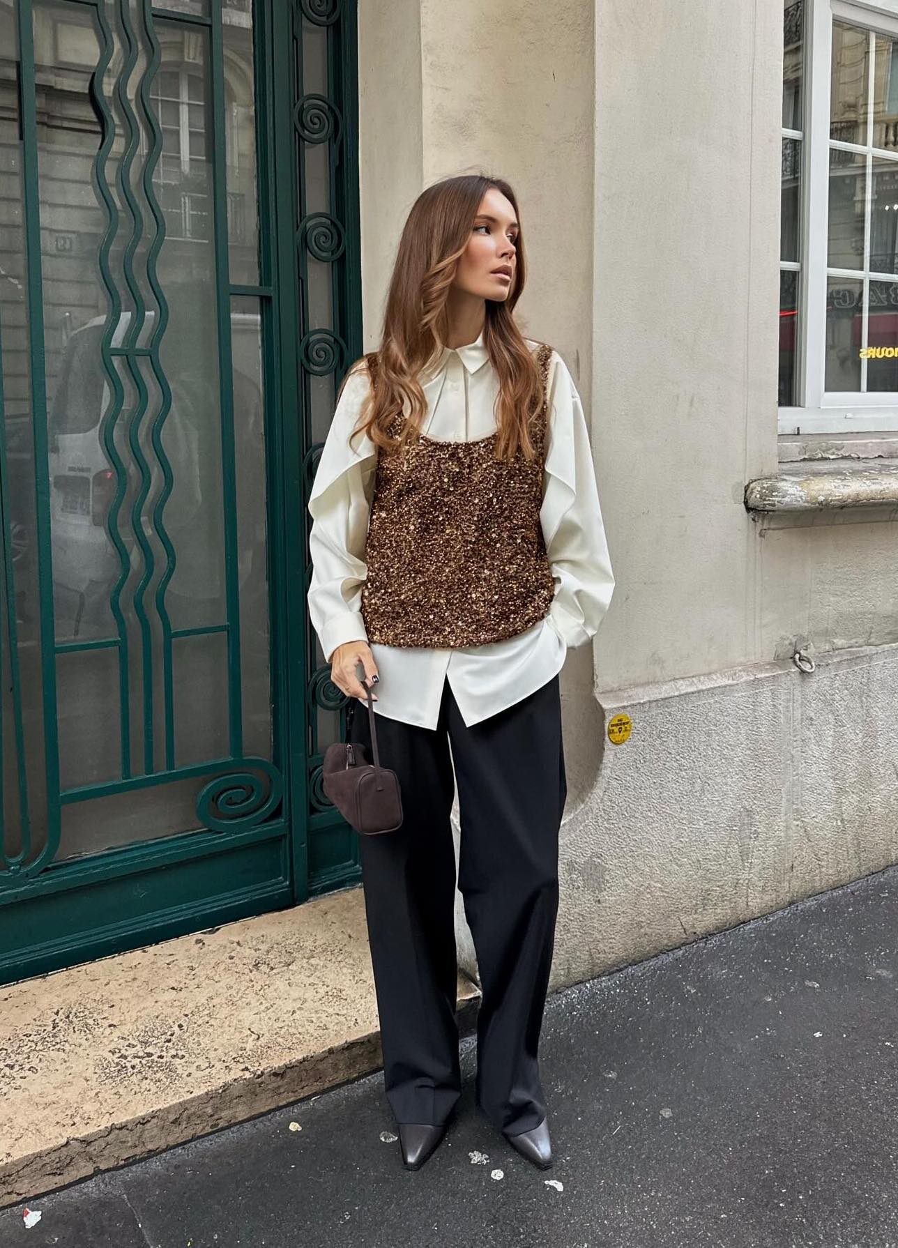 Chic Christmas party outfit with a gold sequin vest and black trousers.