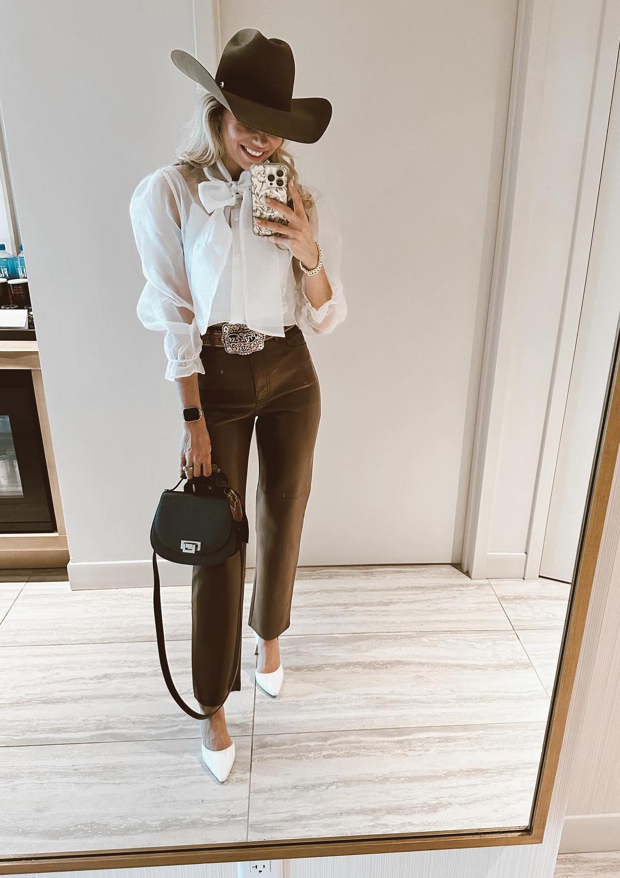 Chic rodeo outfit with brown pants and a white pussy bow shirt.