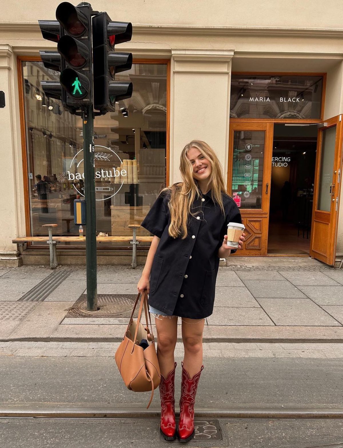 Casual Scandinavian street style outfit with an oversized shirt and red cowboy boots.