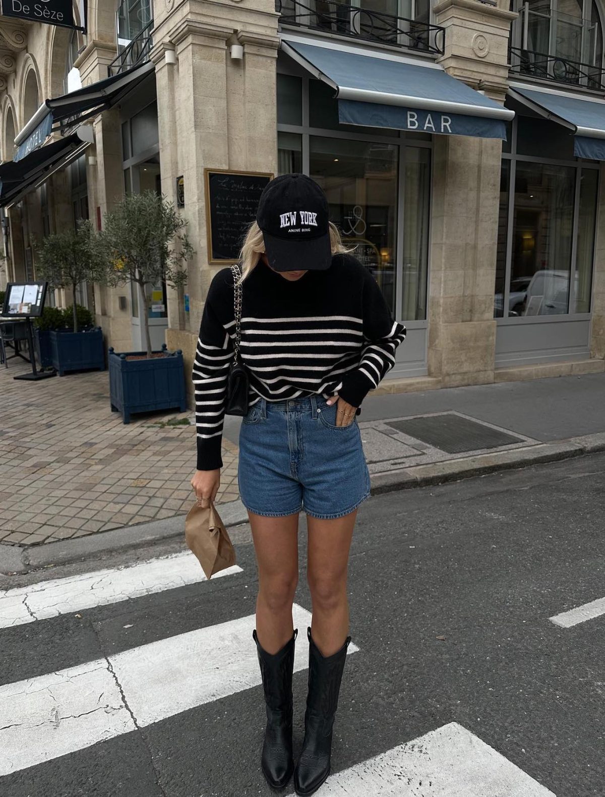 Casual outfit with denim shorts, black cowboy boots and a striped sweater.