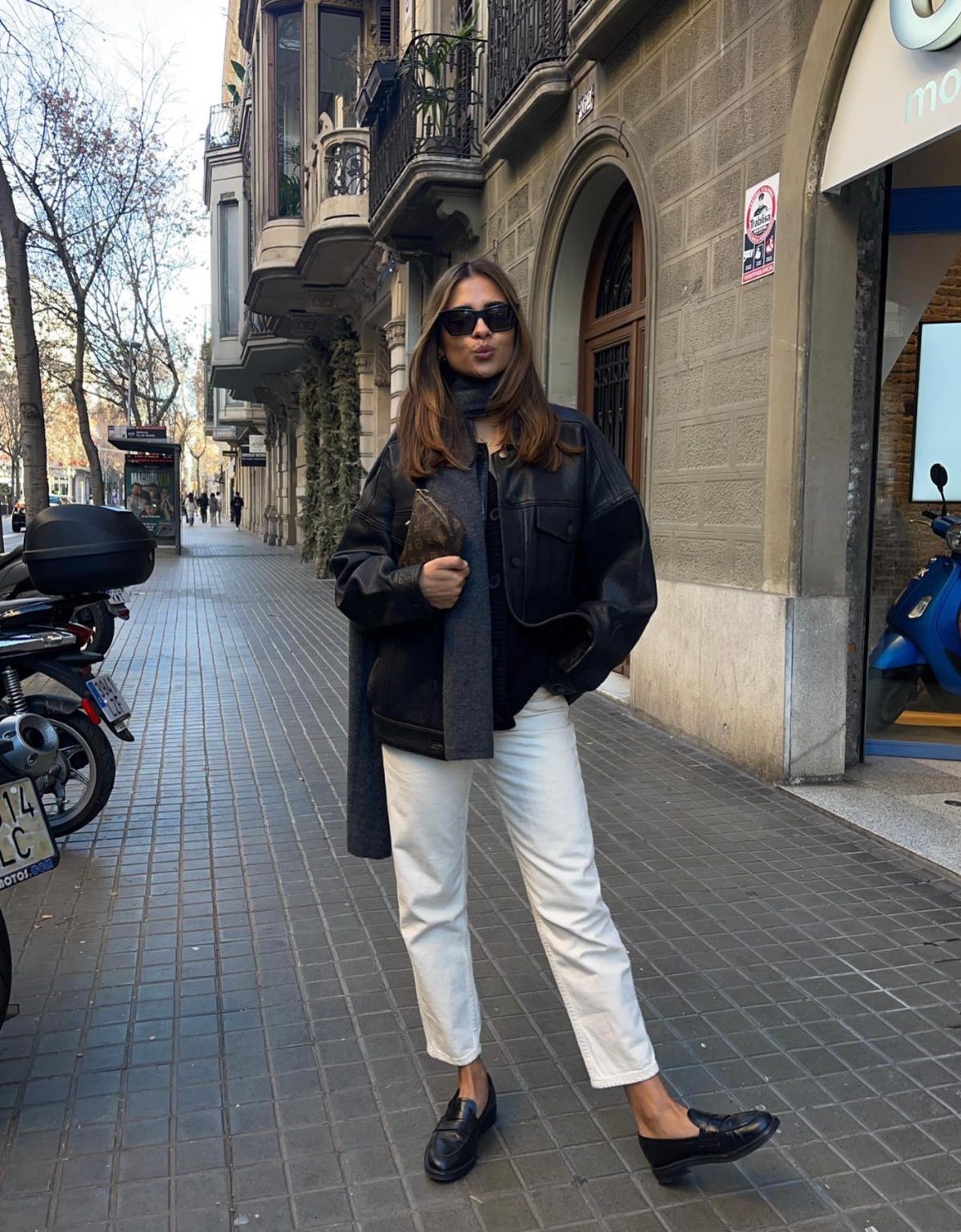 White ankle length jeans with a black jacket and loafers.