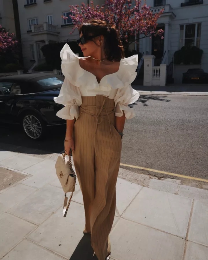 Chic baptism outfit with white statement blouse and pin stripe pants