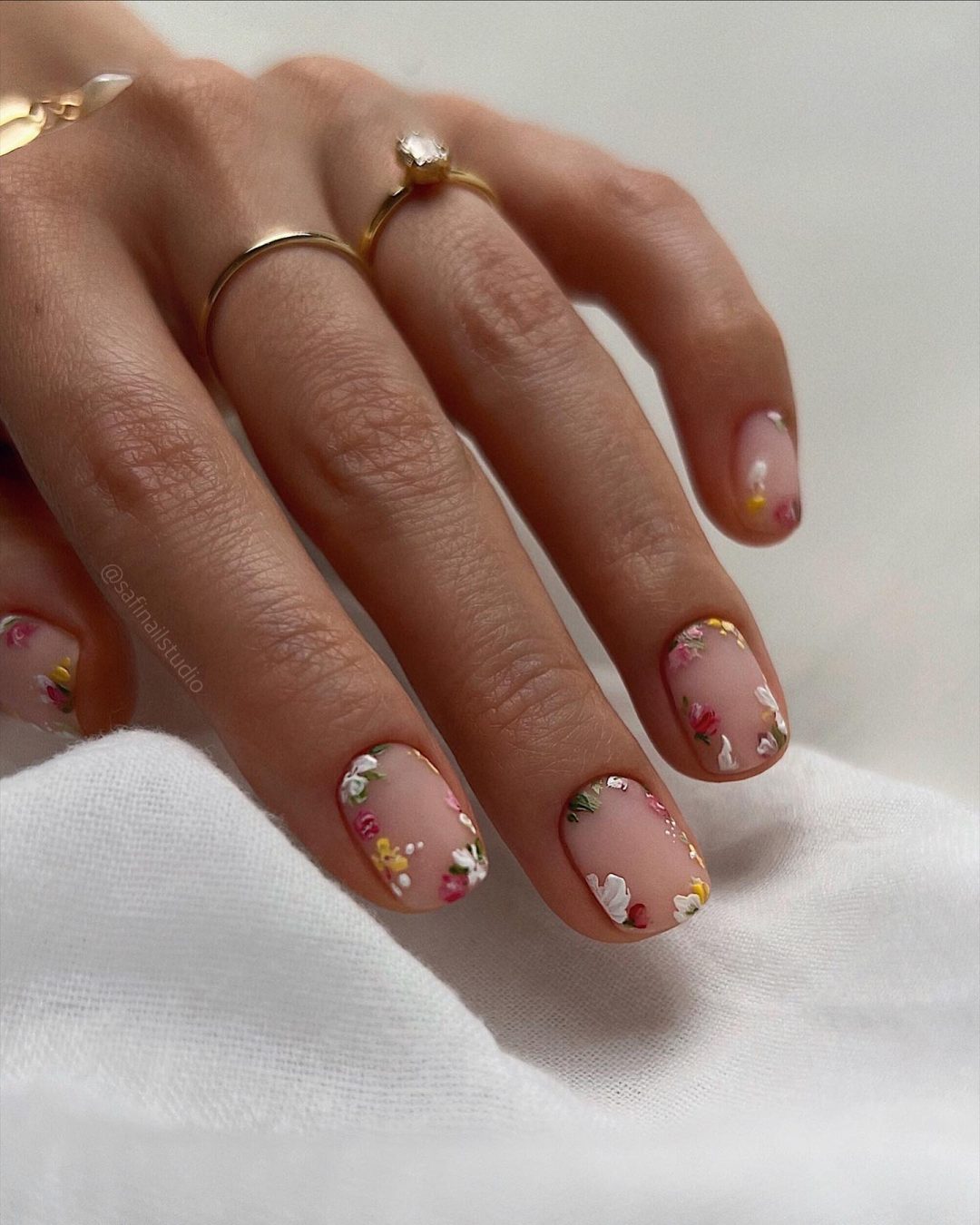 Unhas curtas com flores.