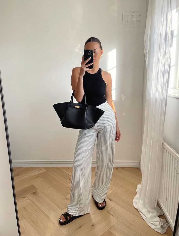 Chic white striped pants outfit with black DeMellier New York tote bag