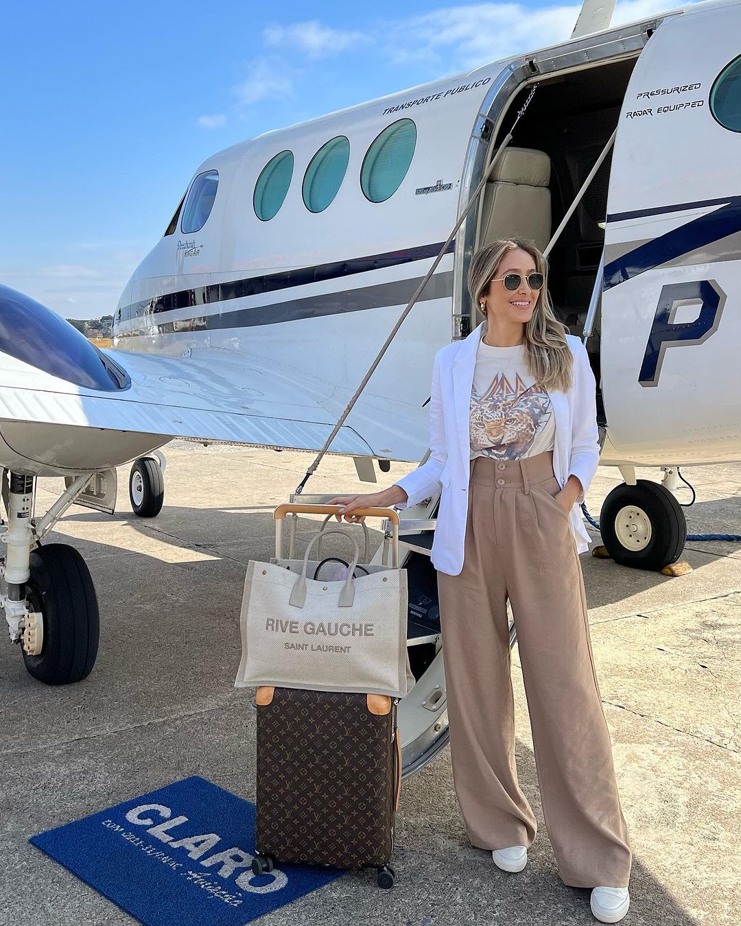 Chic private jet outfit with YSL Rive Gauche bag and Louis Vuitton luggage