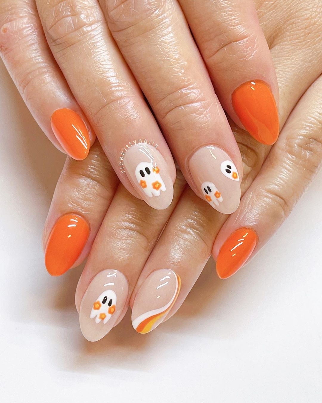 Short orange Halloween nails with ghosts and candy corn