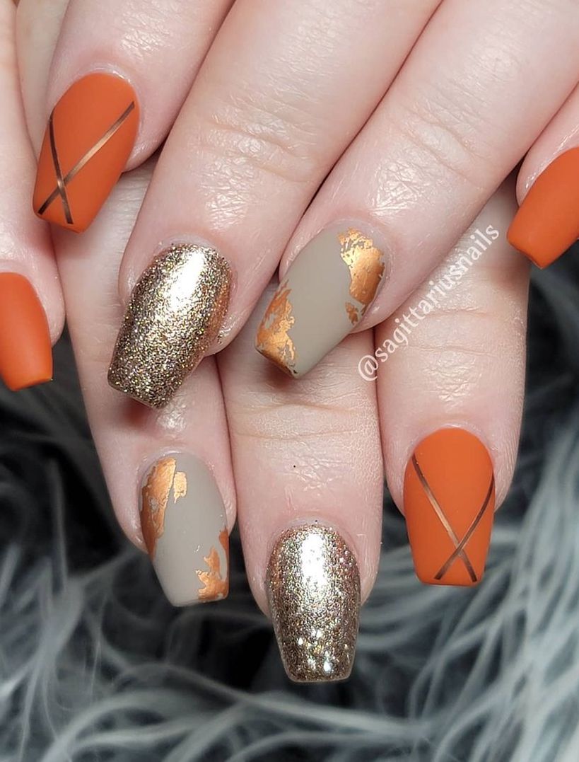 Uñas color naranja quemado mate con diseños grises y dorados