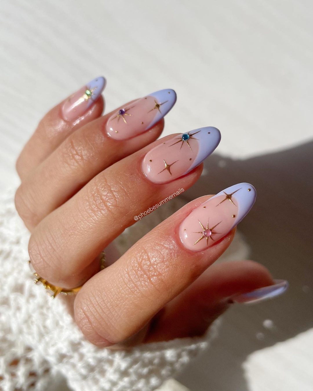 Lavender French tip nails with starts in almond shape.
