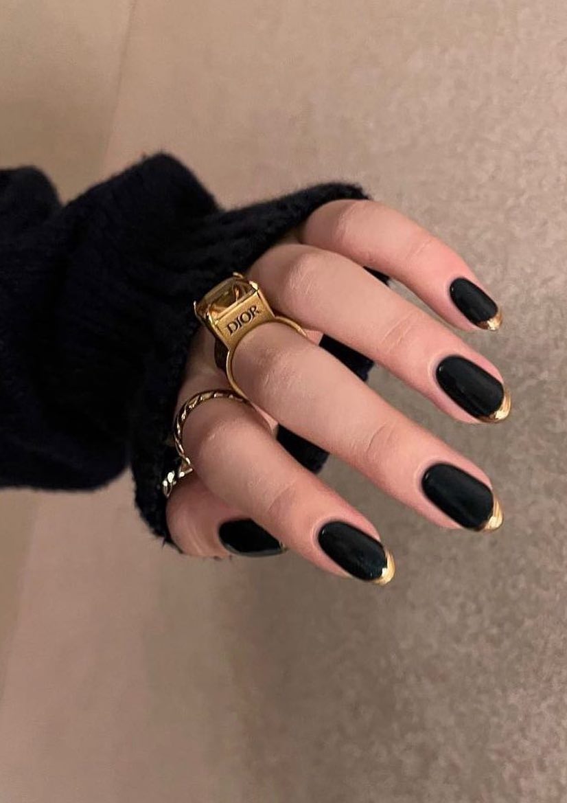 Black nails with gold tips.