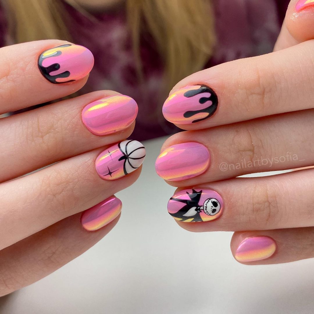 Short pink chrome nails with pumpkins.