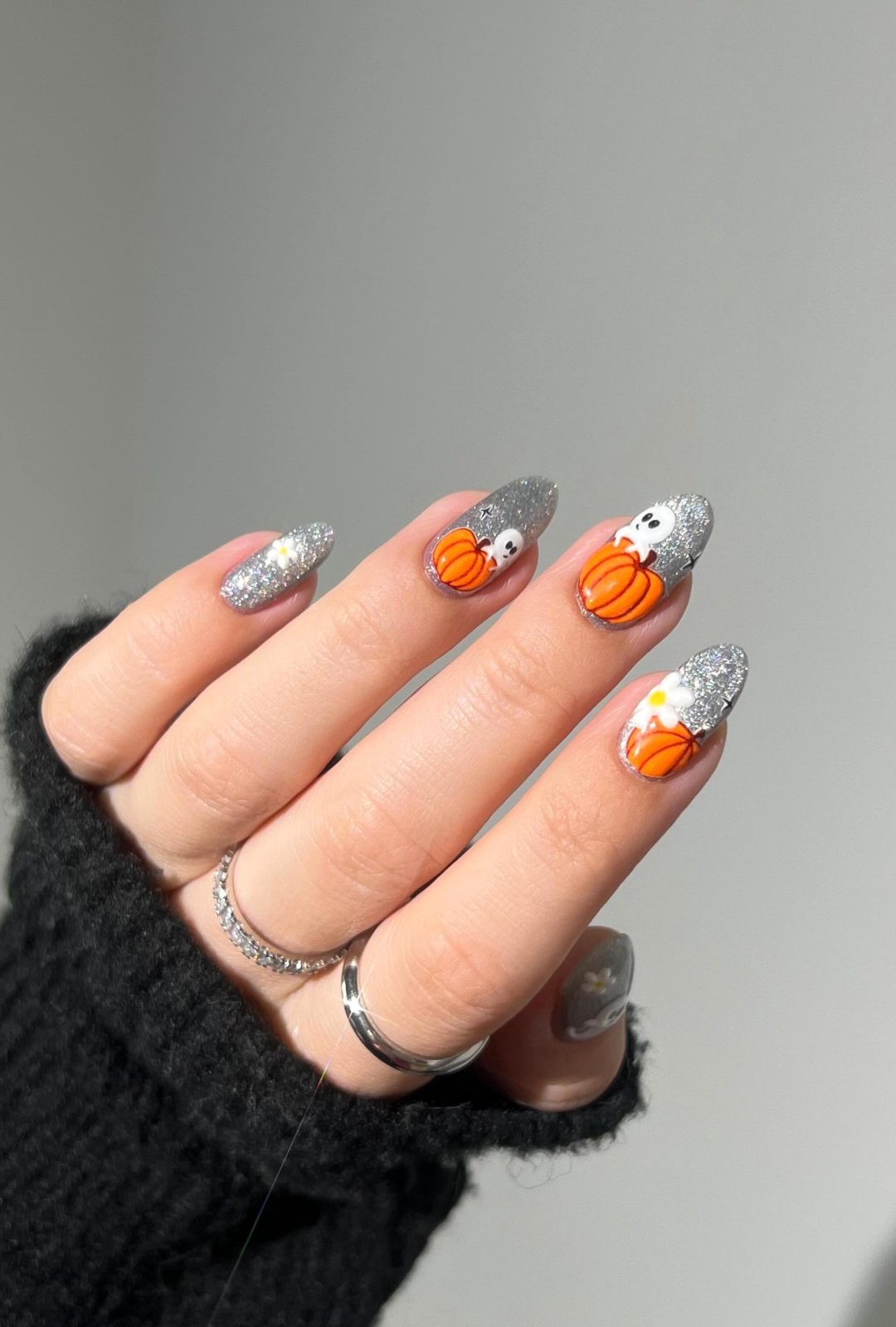 Silver Halloween nails with ghosts and pumpkins.