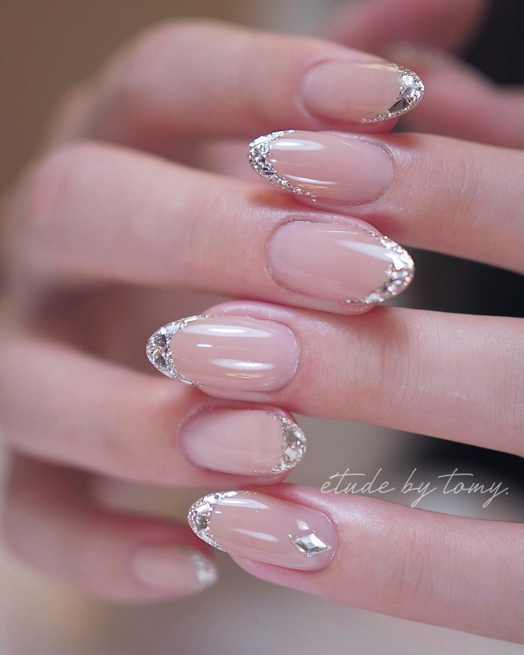 Silver French tip nails with glitter.