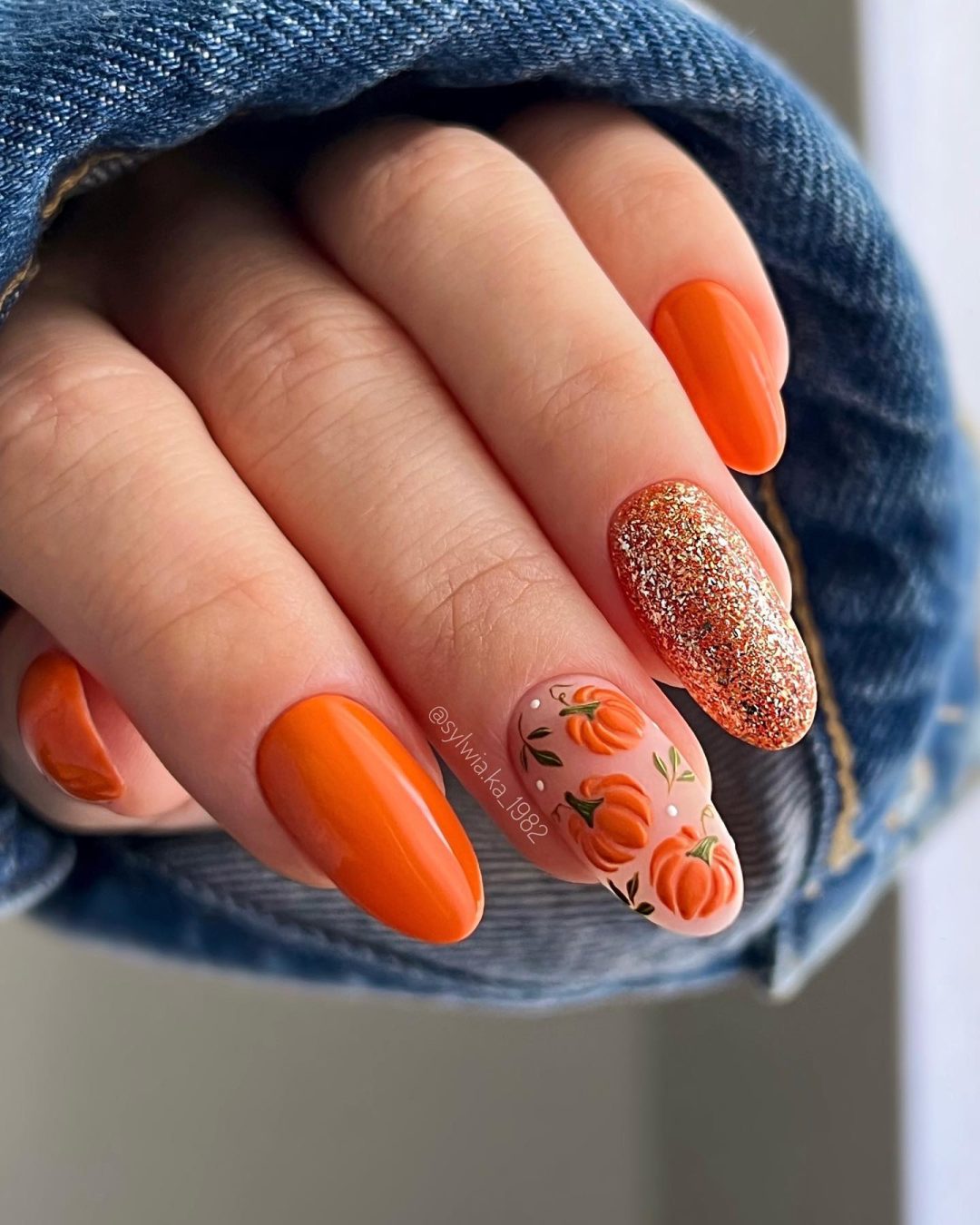 Burnt orange pumpkin nails with gold glitter.