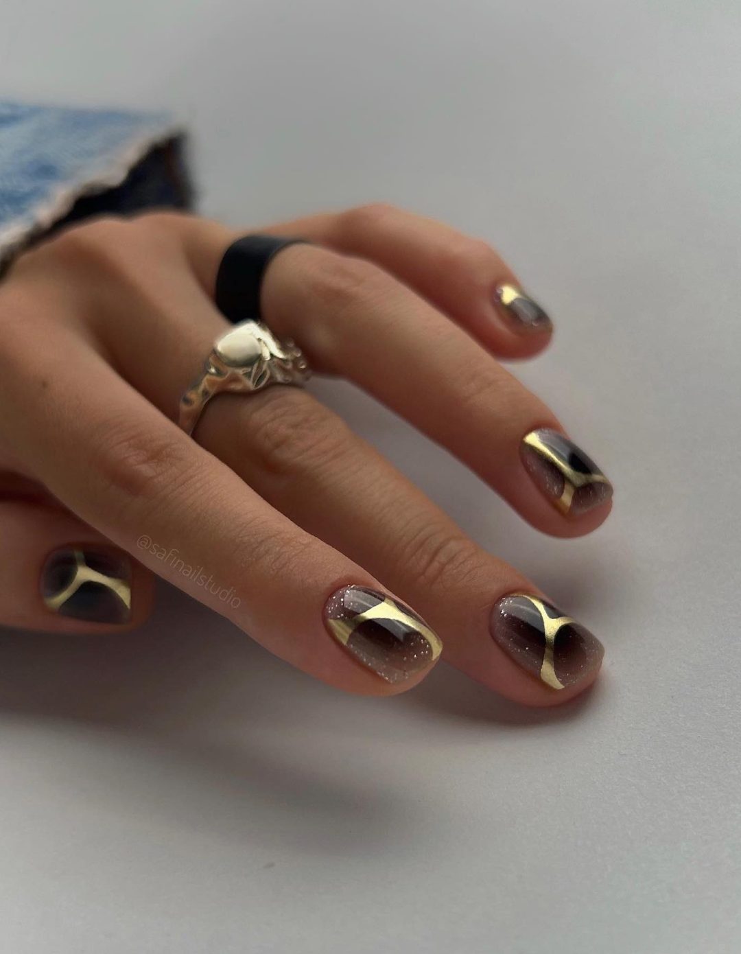 Short black and gold nails.