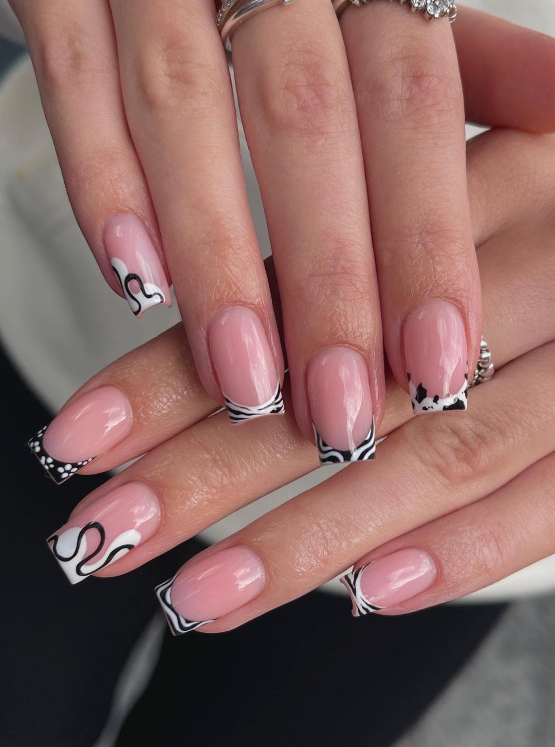 Abstract black and white French tip nails.