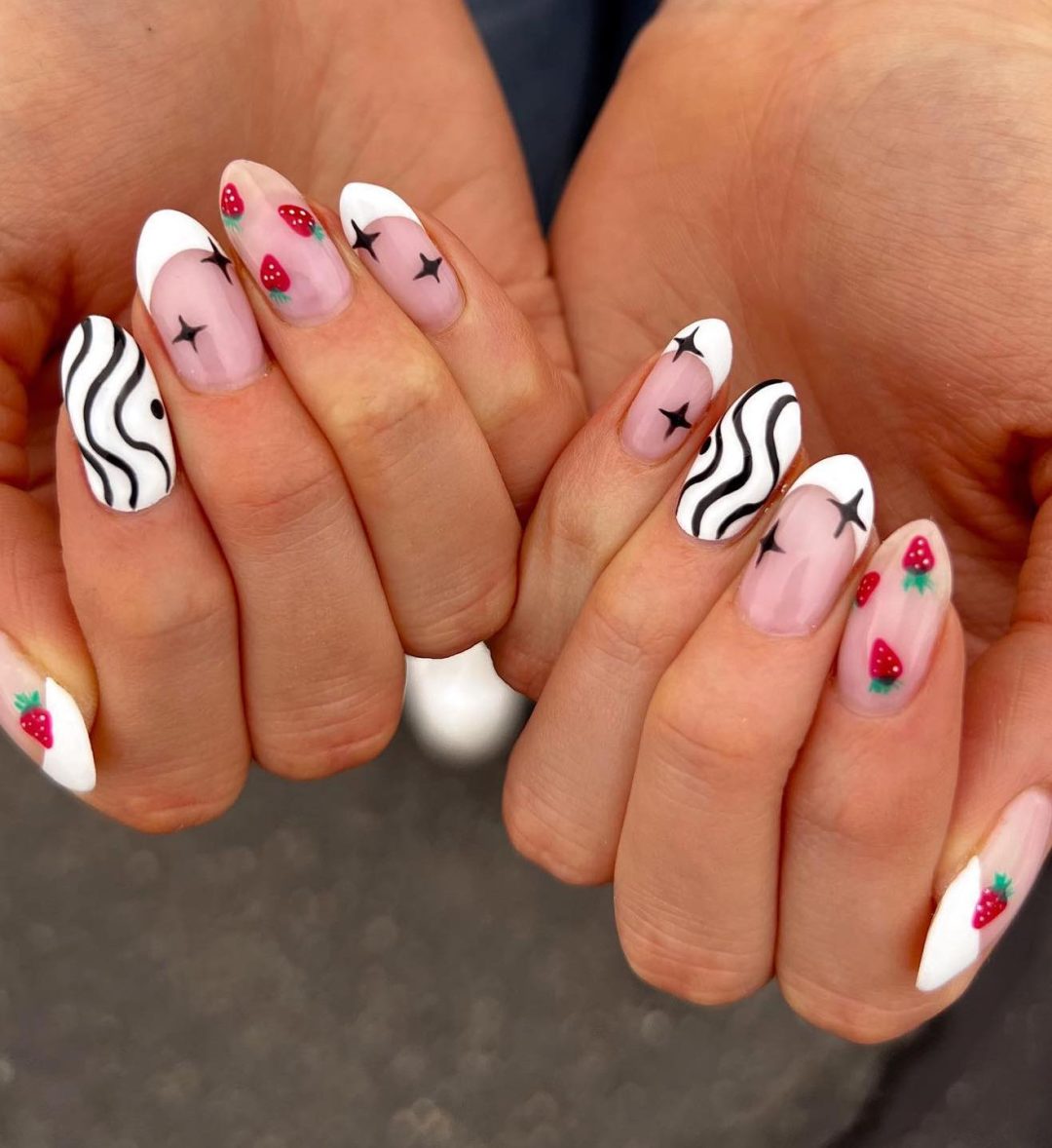 Cute black and white nails with strawberries and stars.