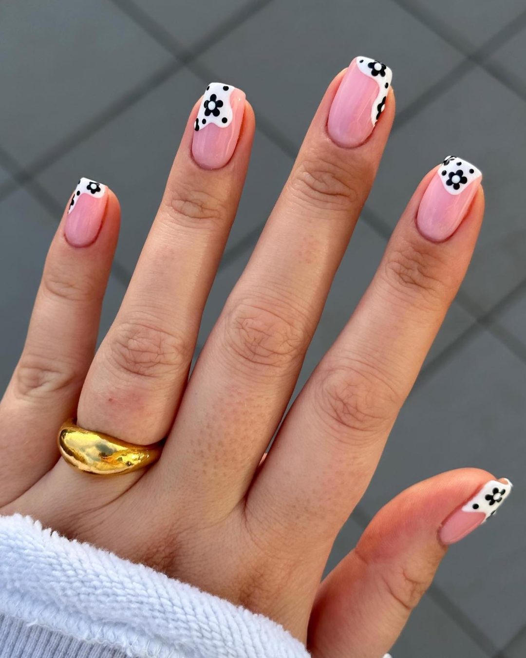 Black and white French tip nails with daisy design.