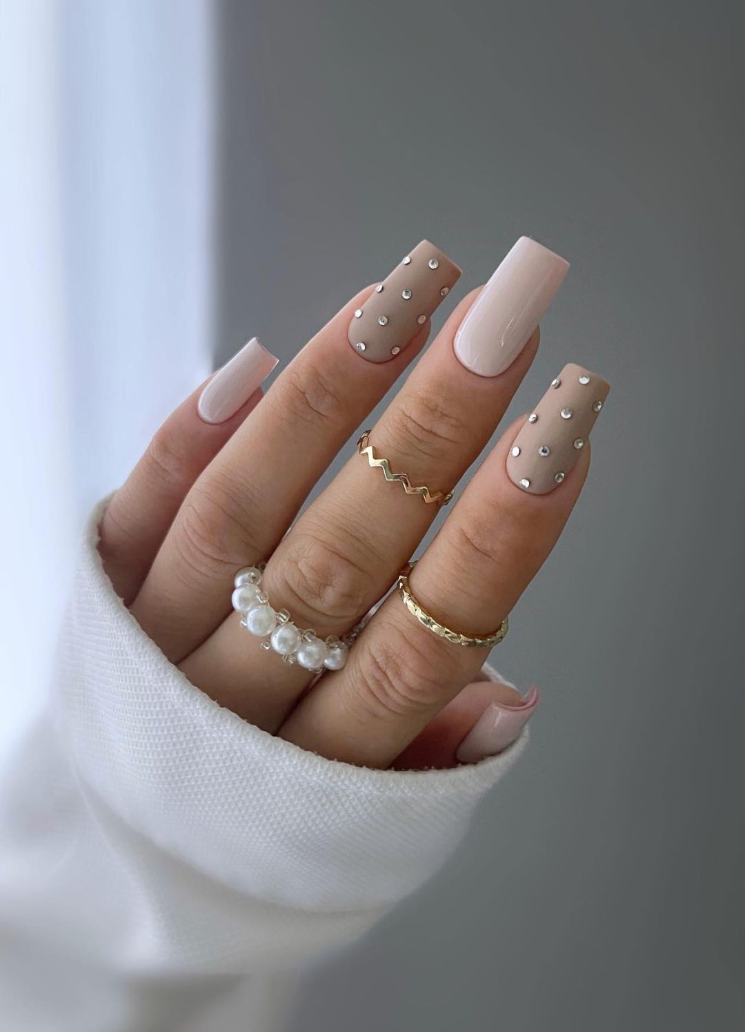 Long neutral nails with crystals.