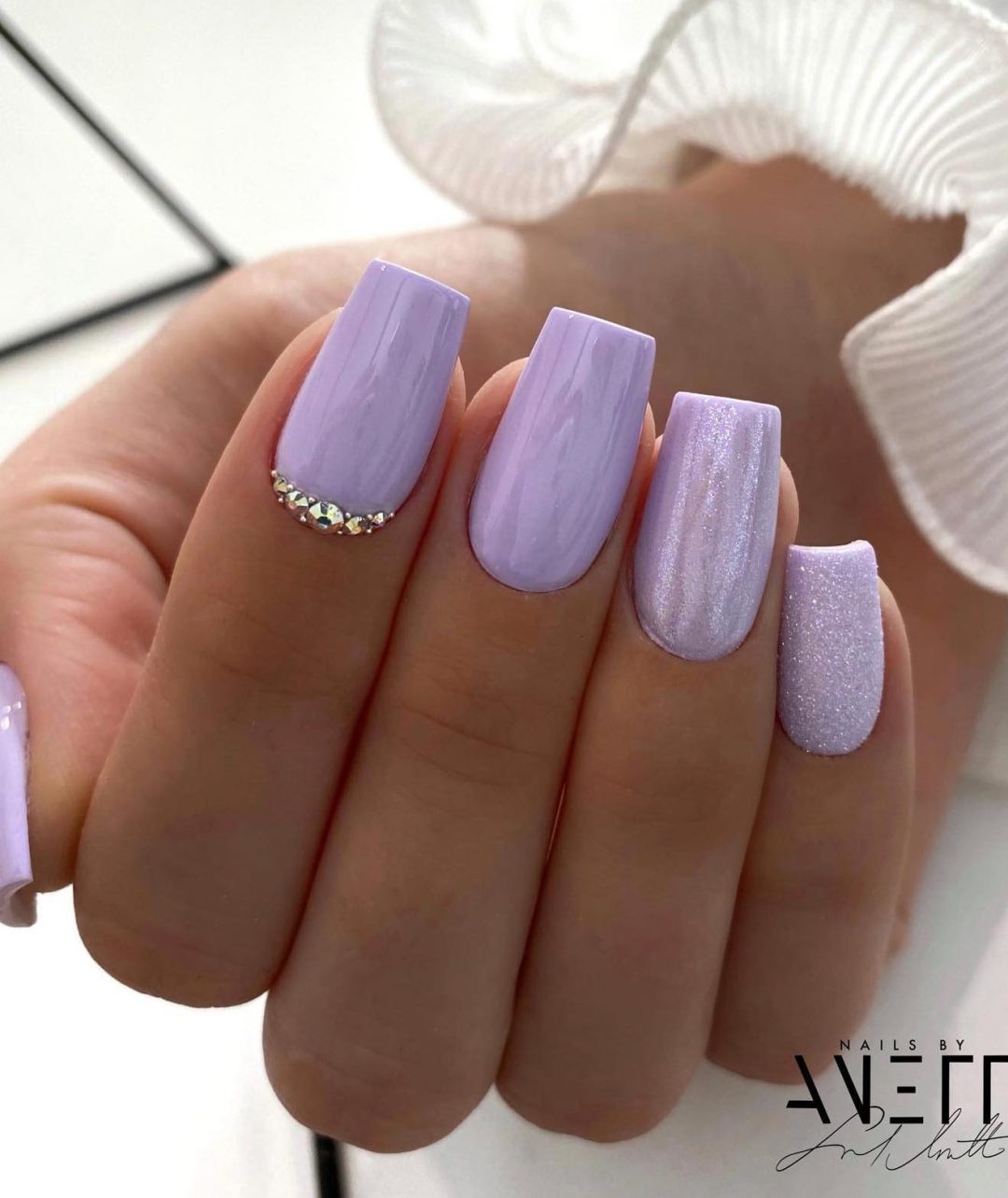 Long light purple nails with crystals.