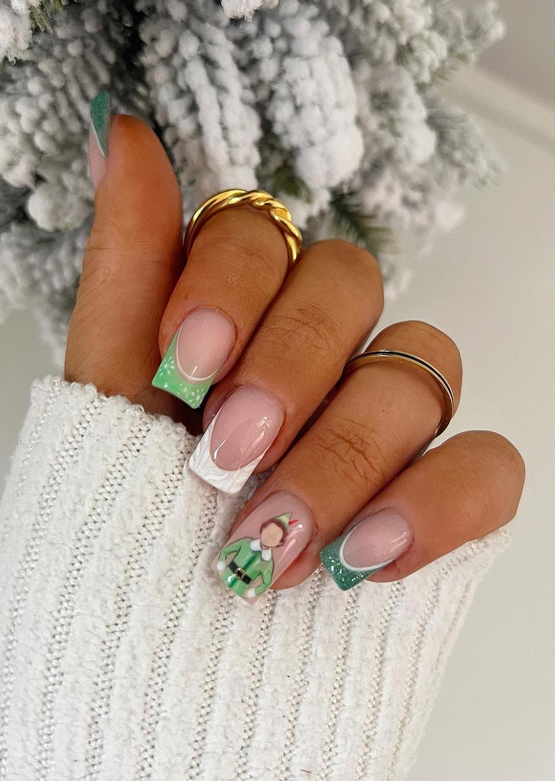 Green Christmas nails with French tips and elf nail art.