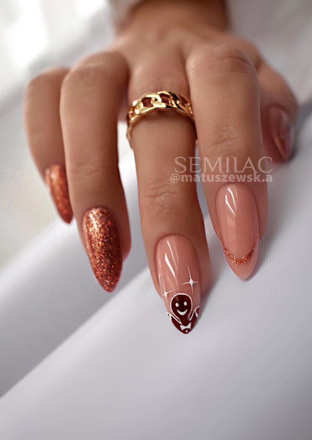 Beige and gold Christmas nails with gingerbread man design.