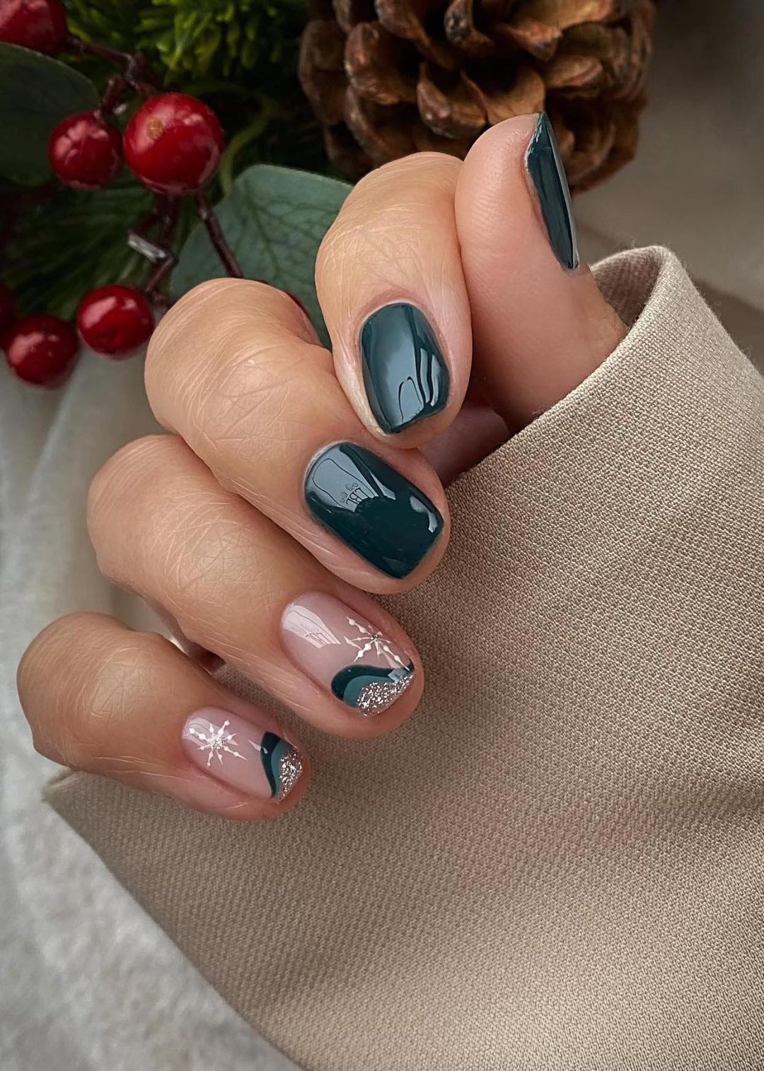 Short emerald green nails with snowflakes.