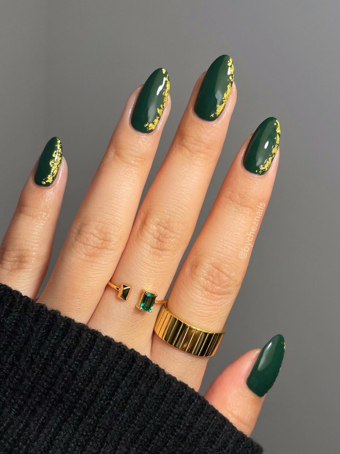 Emerald green nails with gold flakes.