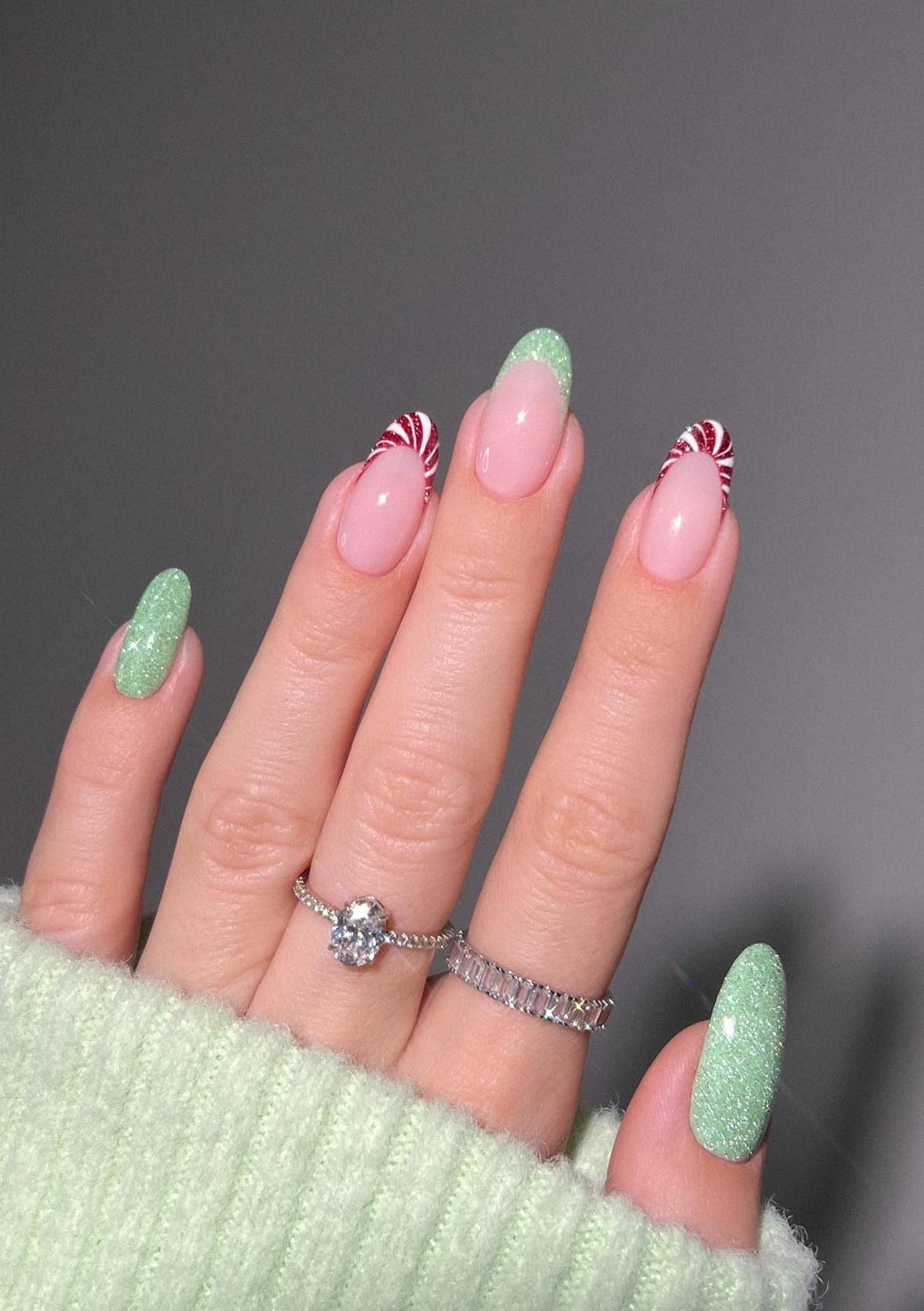 Mint green Christmas nails with candy cane French tips.