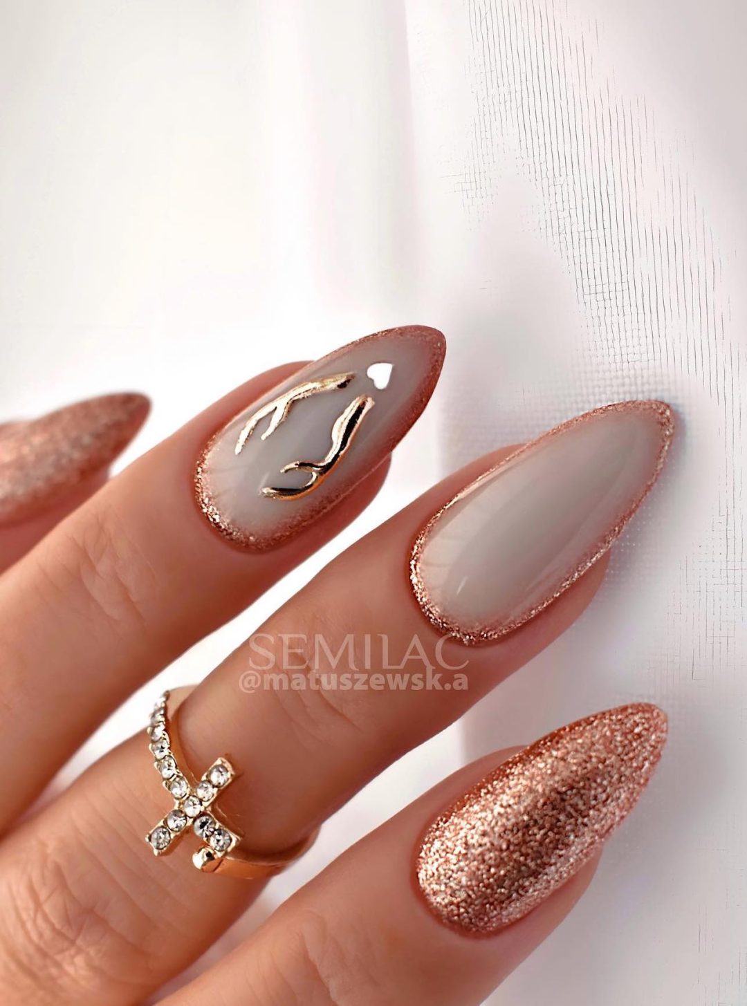 White and gold Christmas nails with reindeer nail art.