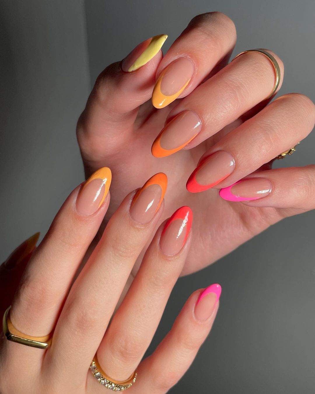 Pink to yellow ombre French tip nails.