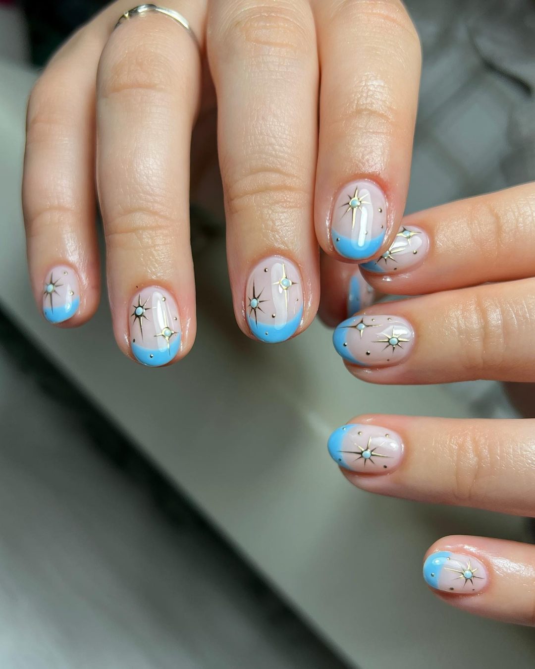 Short light blue French tip nails with stars.