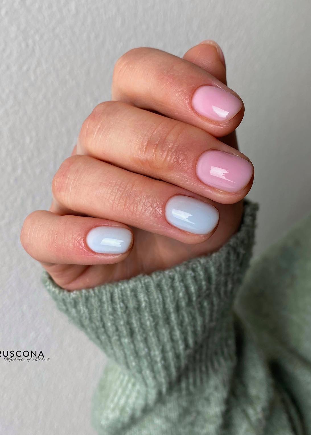 Unhas curtas em azul pastel e rosa.