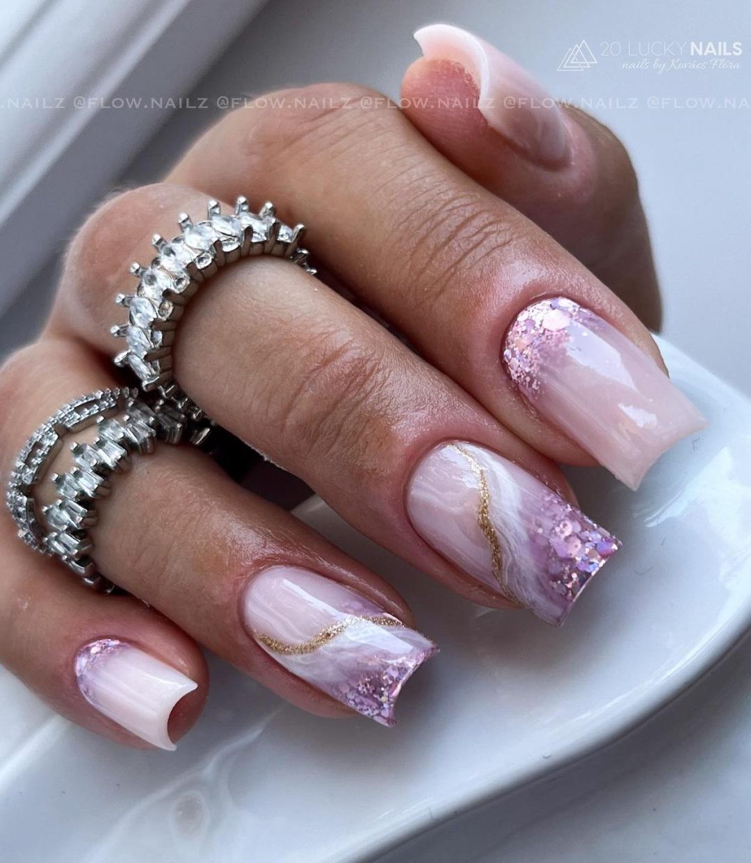 Unhas de mármore rosa com glitter.