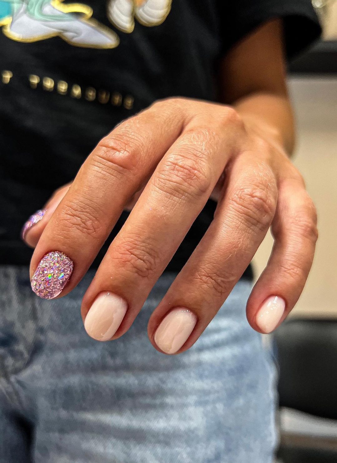 Short beige nails with rose gold glitter.