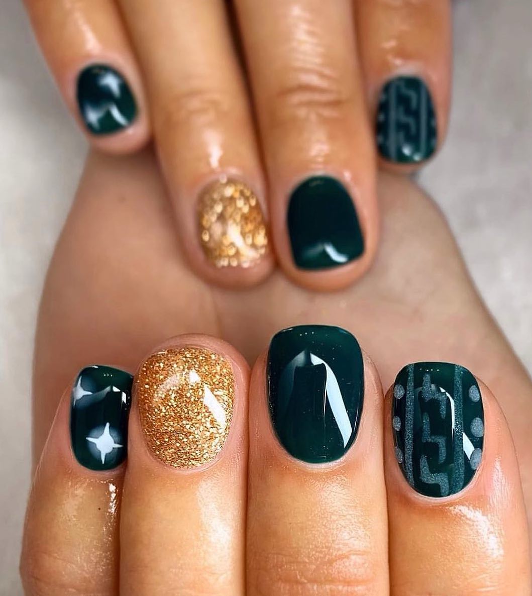 Short emerald green nails with gold glitter.