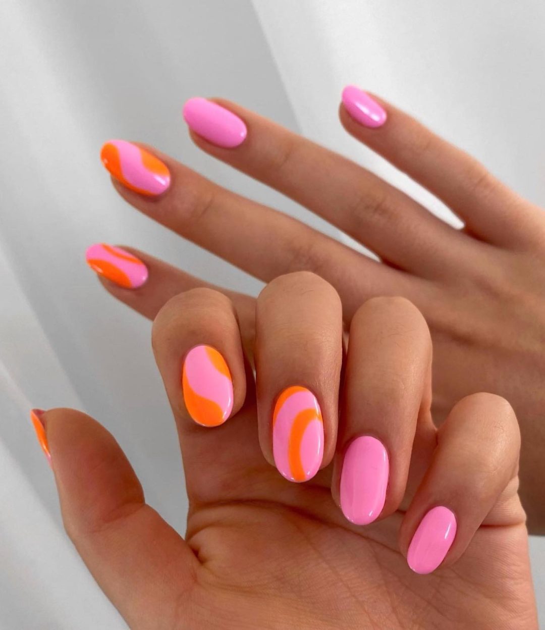 Short pink and orange abstract nails.