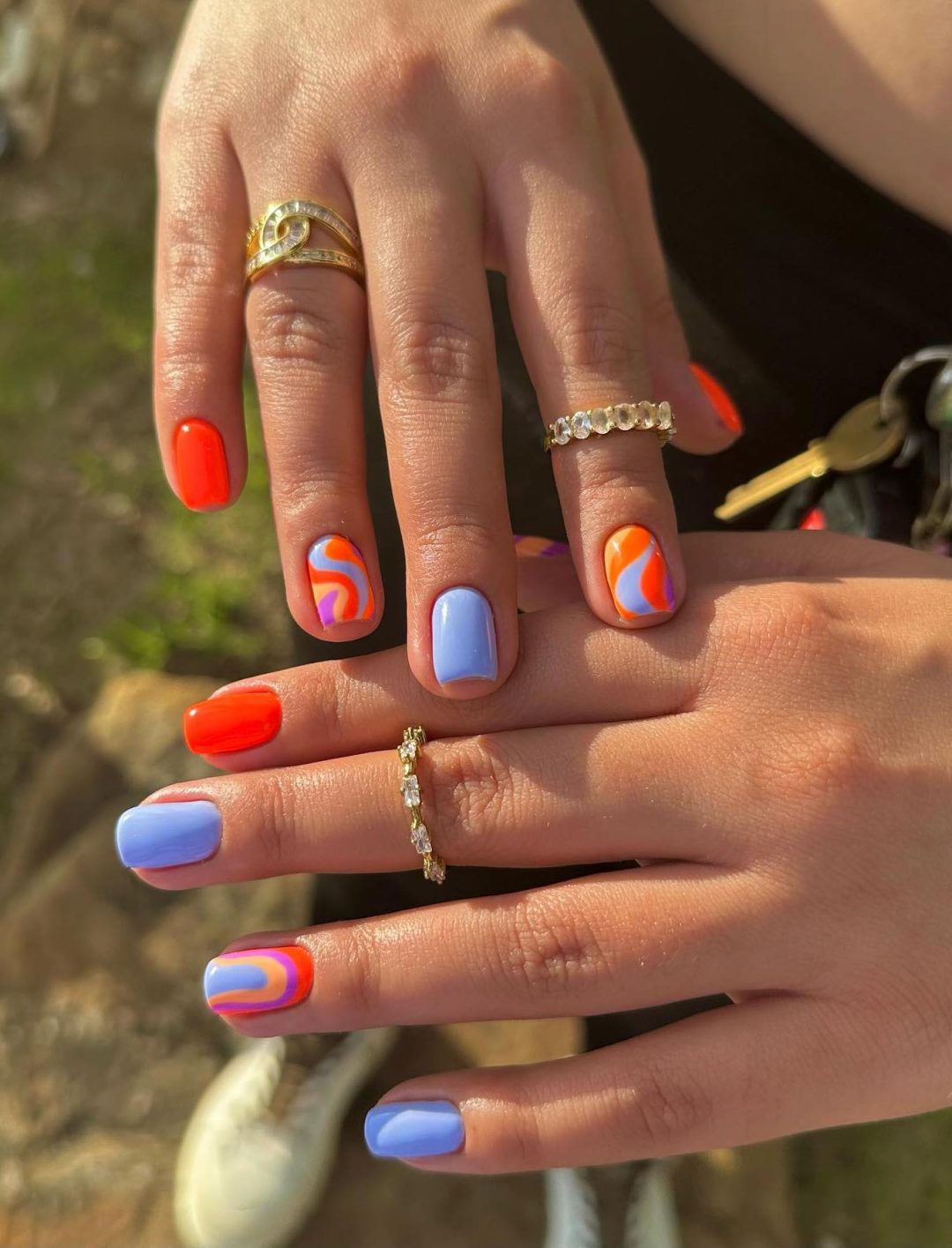 Pastel blue and orange nails with swirls.